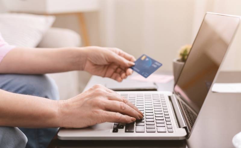 hands using laptop holding credit card online gift shopping